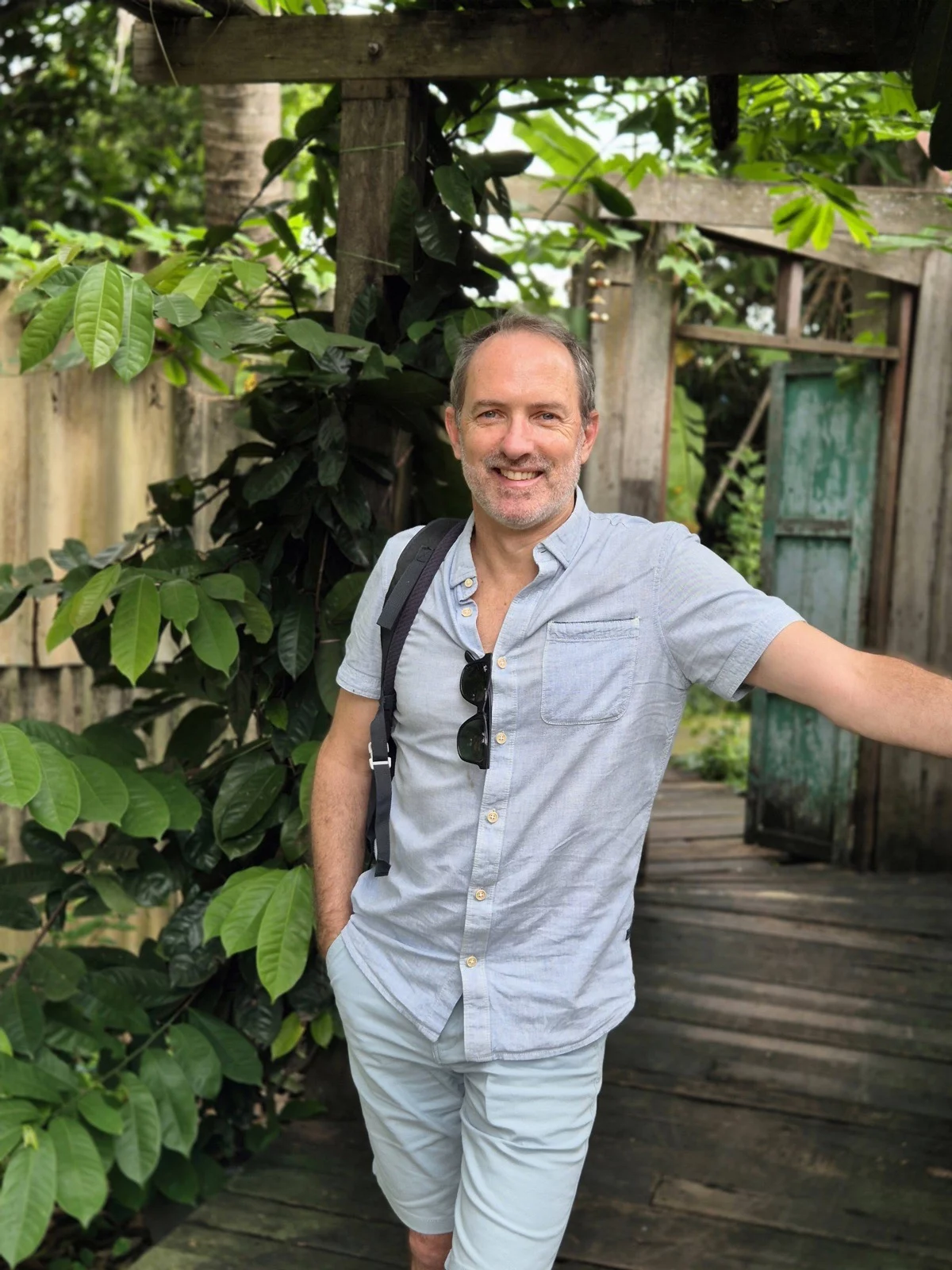 Thomas Schaevers souriant, sac sur l’épaule, dans un jardin tropical en Thaïlande
